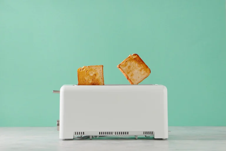 Weißer Langschlitztoaster aus dem zwei goldbraune Toastscheiben springen