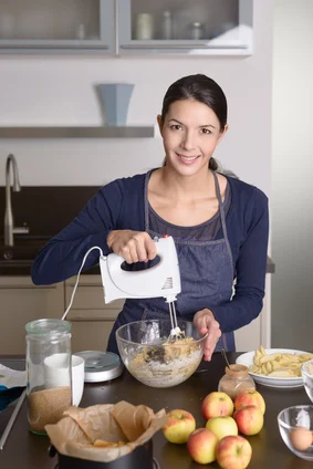 Junge Frau benutzt Handmixer