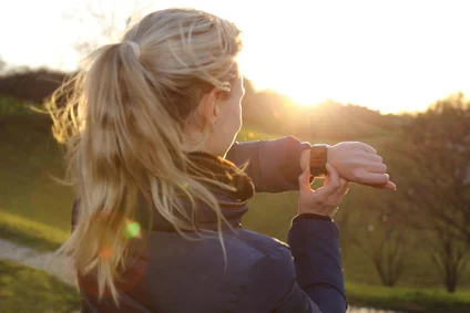 Frau bedient Smartwatch im Park